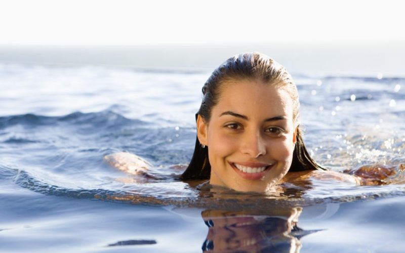 Woman swimming in infinity pool
